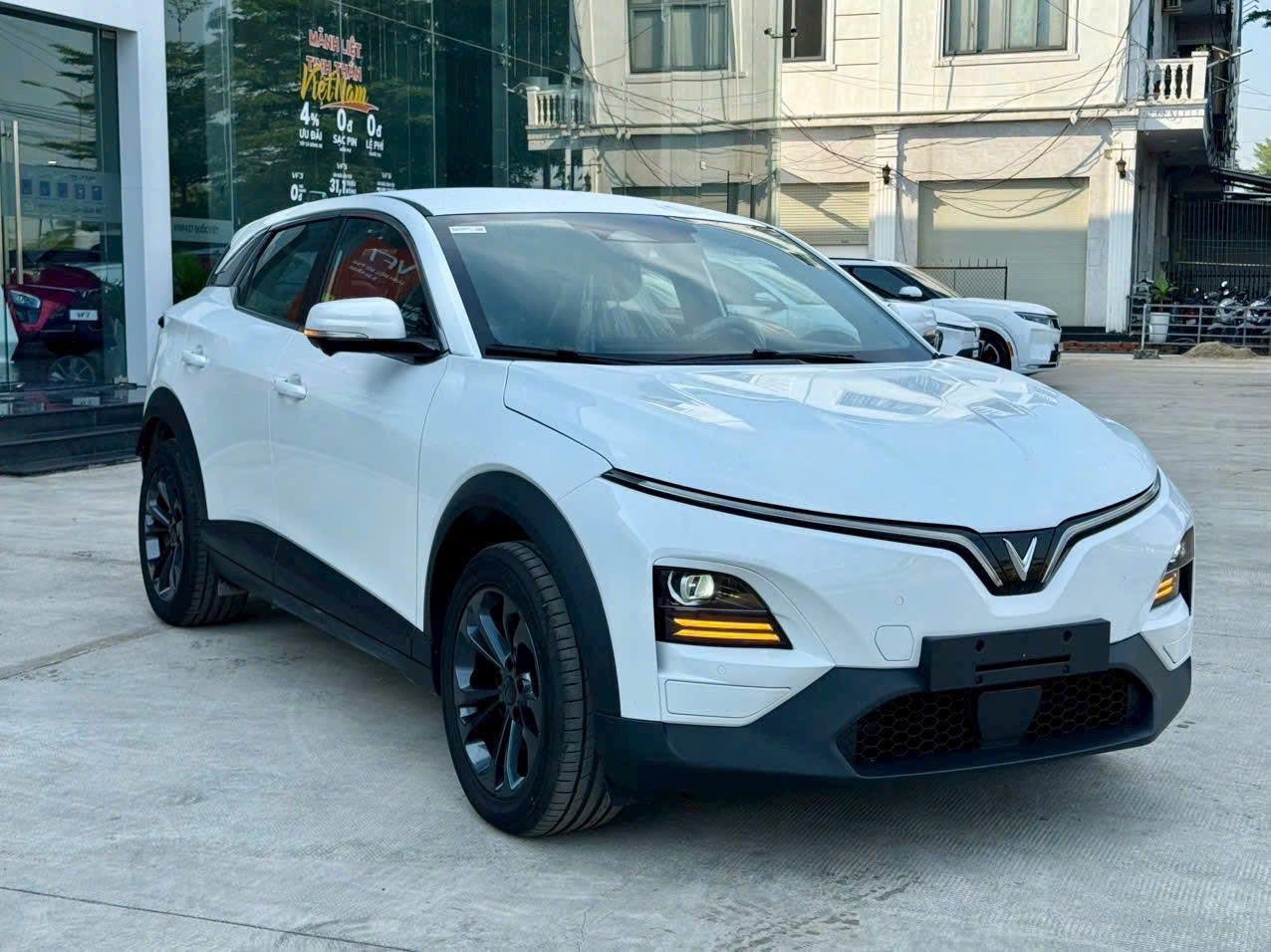 VinFast VF6 màu trắng nhìn từ góc trước ngoài showroom